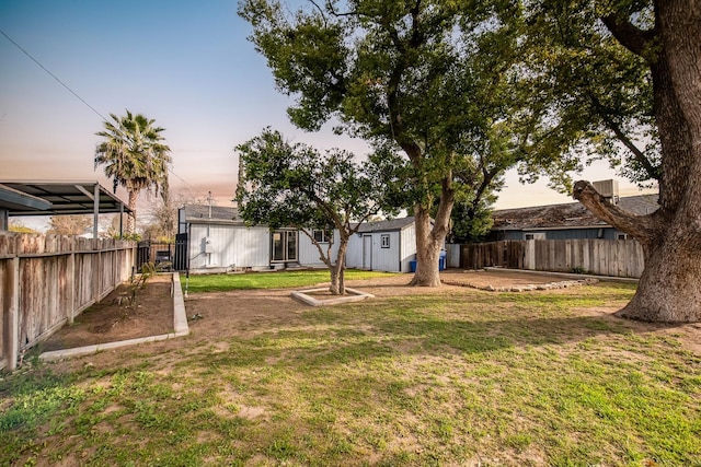 view of yard with a fenced backyard and an outbuilding