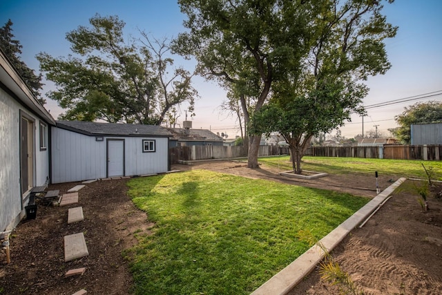 yard at dusk featuring a fenced backyard