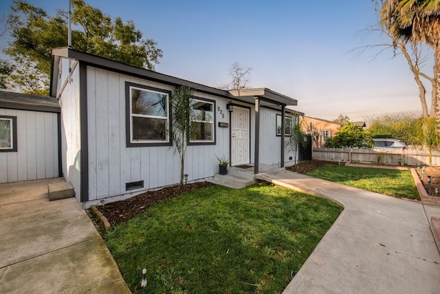 view of front facade with a yard, crawl space, and fence