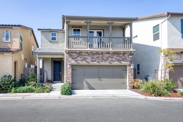 view of front of house with a garage, concrete driveway, a balcony, stucco siding, and brick siding