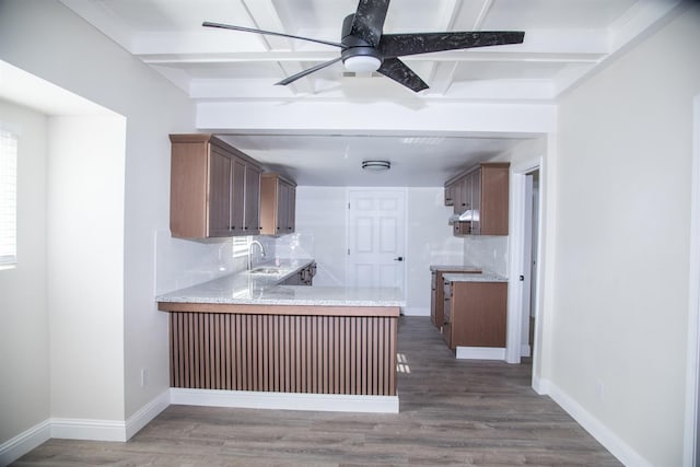 kitchen with beam ceiling, light countertops, baseboards, and wood finished floors