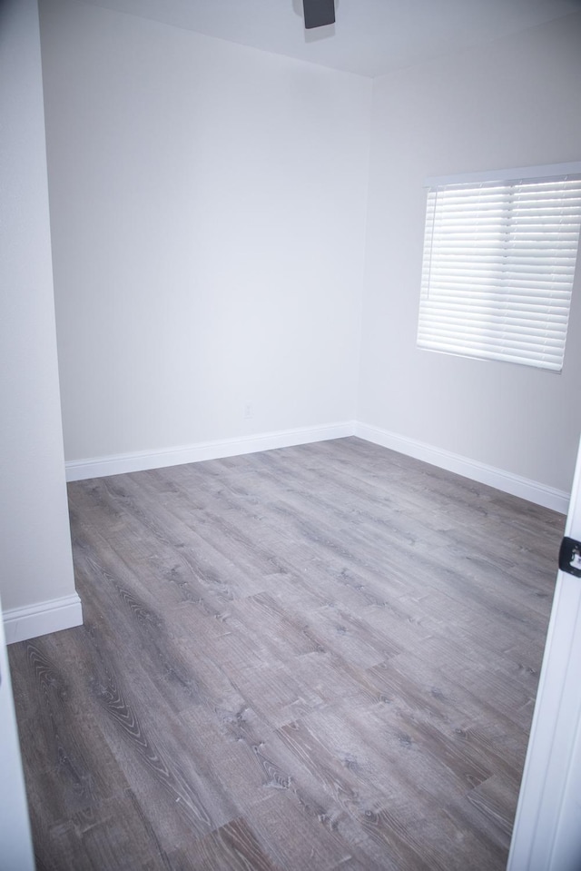 spare room featuring wood finished floors and baseboards