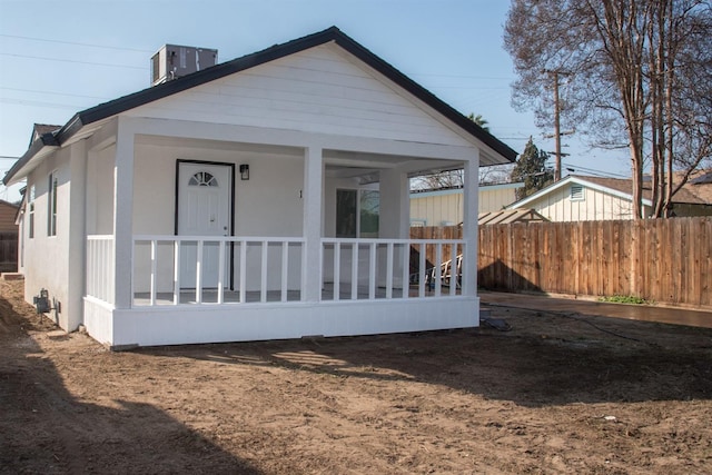 view of front facade with a porch, cooling unit, and fence