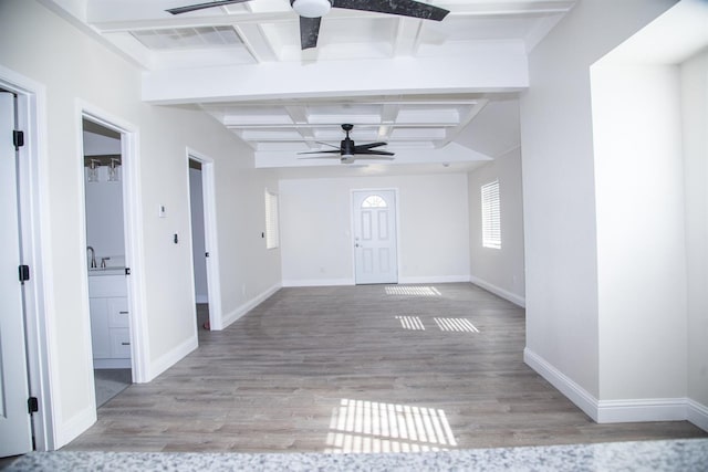 interior space with beamed ceiling, baseboards, a ceiling fan, and wood finished floors