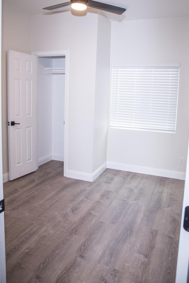 spare room featuring a ceiling fan, baseboards, and wood finished floors