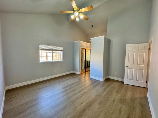 unfurnished bedroom featuring high vaulted ceiling, ceiling fan, baseboards, and wood finished floors