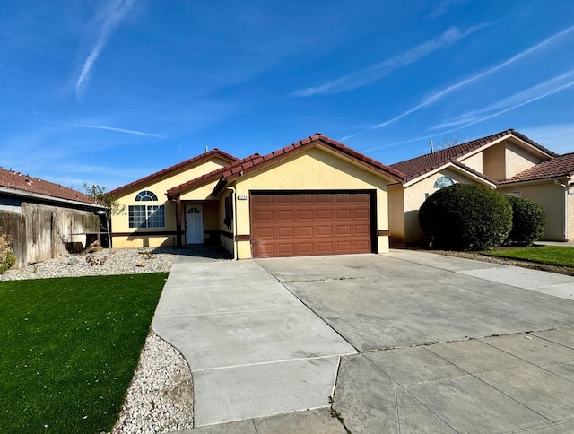 view of front of house featuring concrete driveway, stucco siding, a tiled roof, an attached garage, and a front yard