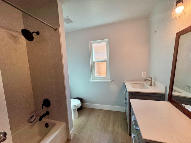 full bath with visible vents, toilet, vanity, wood finished floors, and baseboards