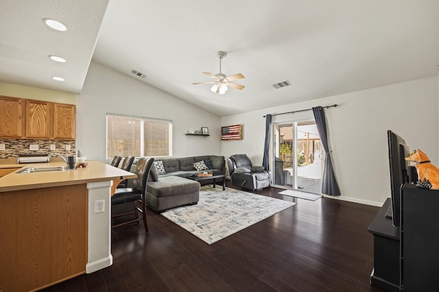 living area featuring lofted ceiling, dark wood-style floors, ceiling fan, and visible vents