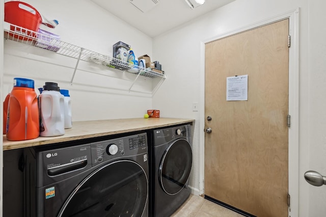 laundry room with laundry area, light tile patterned flooring, and washing machine and clothes dryer