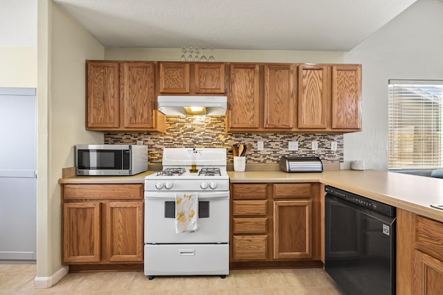 kitchen with exhaust hood, white range with gas cooktop, light countertops, dishwasher, and stainless steel microwave