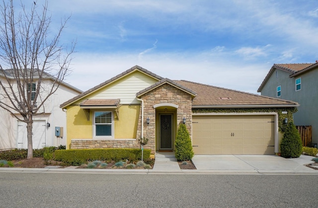 view of front of home featuring a garage, stone siding, a tile roof, and driveway