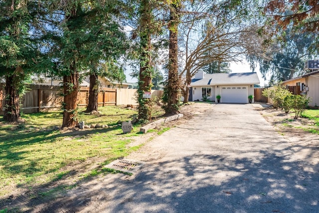 view of front of house featuring a garage, driveway, and fence