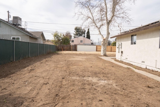 view of yard with a fenced backyard and central AC unit