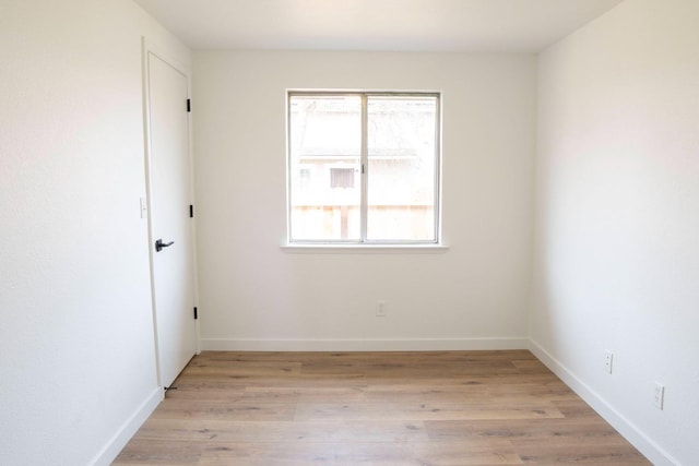 spare room with light wood finished floors, baseboards, and a wealth of natural light