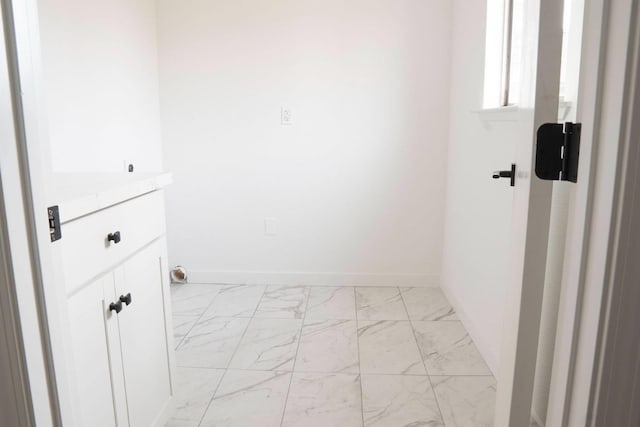 interior space featuring marble finish floor and baseboards