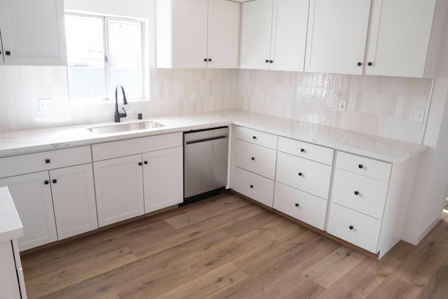 kitchen featuring decorative backsplash, white cabinetry, a sink, light wood-type flooring, and dishwasher