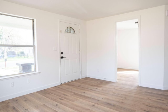 foyer featuring baseboards and light wood-style floors