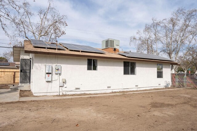 rear view of property with crawl space, central air condition unit, fence, and stucco siding