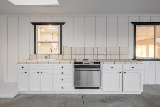 42906 Ranger Circle Dr Drive, Coarsegold, CA 93614 - kitchen with tile countertops, stainless steel electric range oven, backsplash, and white cabinetry