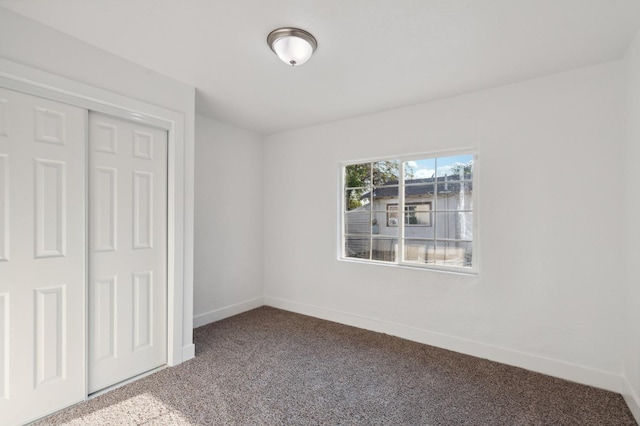 unfurnished bedroom with a closet, carpet flooring, and baseboards