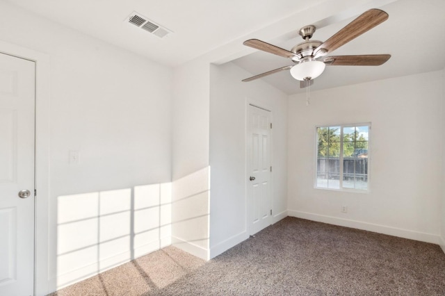 carpeted spare room with ceiling fan, visible vents, and baseboards