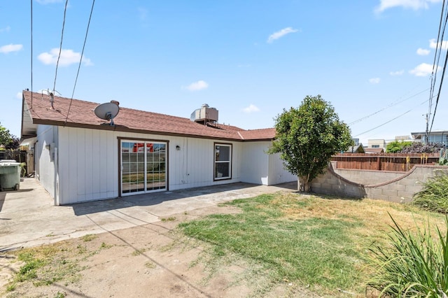 back of property featuring a yard, a patio area, and fence