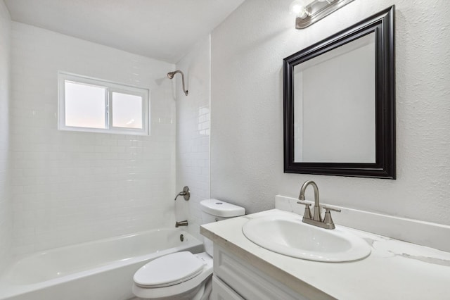 bathroom with toilet, vanity, shower / bathing tub combination, and a textured wall