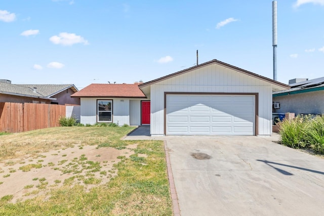 ranch-style home featuring a front yard, fence, and an attached garage