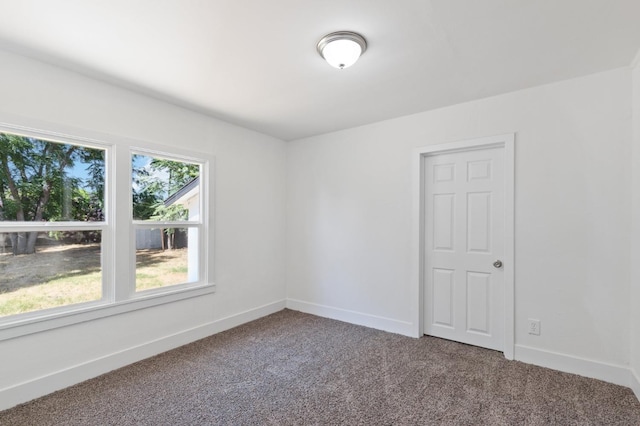 spare room featuring carpet and baseboards