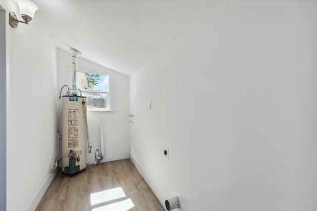 laundry room with light wood-style flooring, hookup for an electric dryer, laundry area, baseboards, and water heater