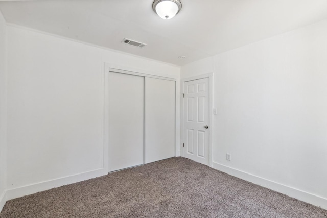 unfurnished bedroom with a closet, visible vents, baseboards, and carpet flooring