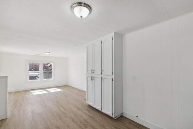 additional living space featuring light wood finished floors and baseboards