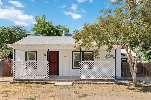 view of front facade featuring covered porch and fence