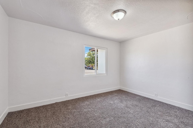 unfurnished room with a textured ceiling, carpet, and baseboards