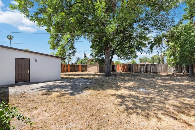 view of yard with a fenced backyard and an outdoor structure