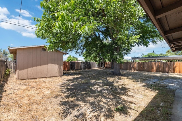 view of yard featuring a shed, an outdoor structure, and a fenced backyard