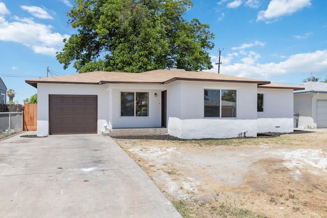 ranch-style house with driveway, a garage, fence, and stucco siding