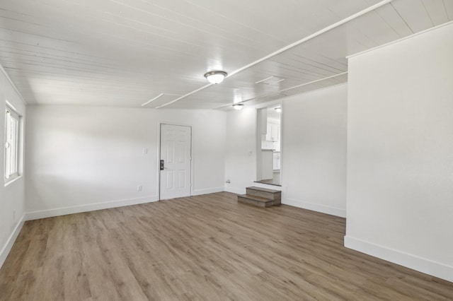 unfurnished room featuring wood ceiling, baseboards, and light wood finished floors