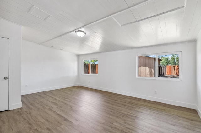 spare room with wooden ceiling, wood finished floors, and baseboards