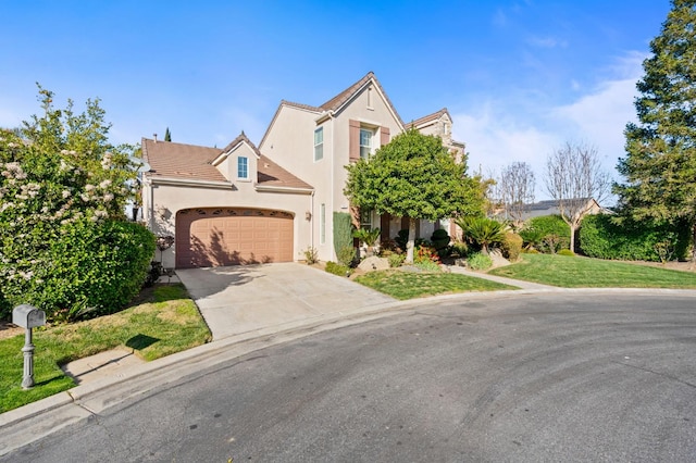 view of front of home with an attached garage, a tile roof, concrete driveway, stucco siding, and a front yard