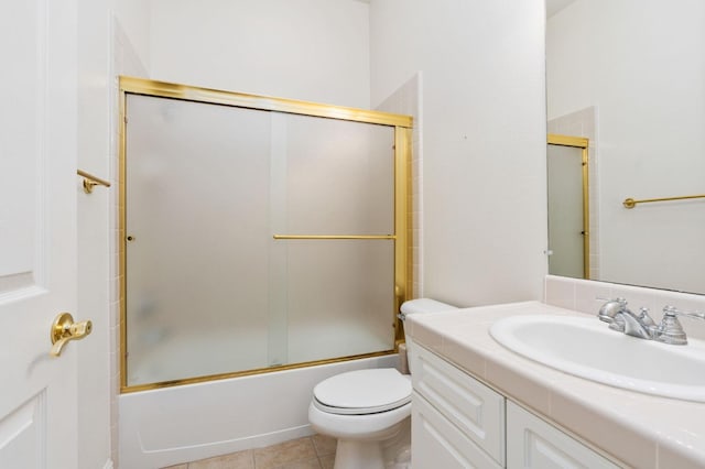 bathroom featuring bath / shower combo with glass door, vanity, toilet, and tile patterned floors