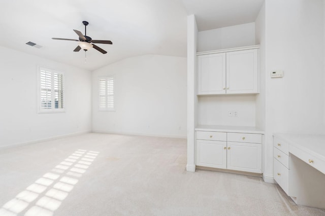 unfurnished living room featuring baseboards, visible vents, a ceiling fan, light colored carpet, and lofted ceiling