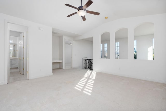 empty room with carpet floors, lofted ceiling, baseboards, and a ceiling fan