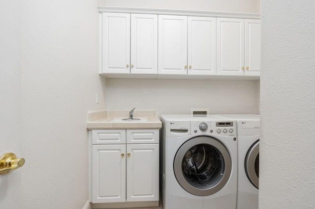 laundry room featuring a sink, washing machine and dryer, and cabinet space