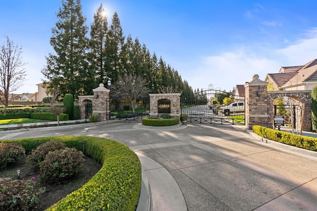 exterior space with a gate, curbs, and a gated entry