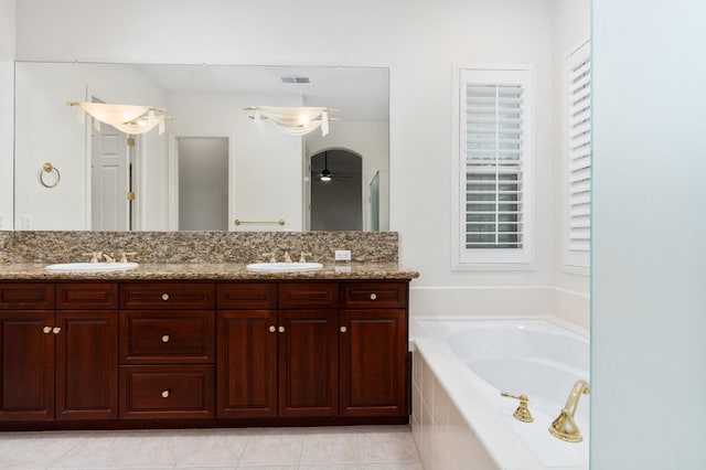 bathroom with visible vents, a sink, a garden tub, and double vanity