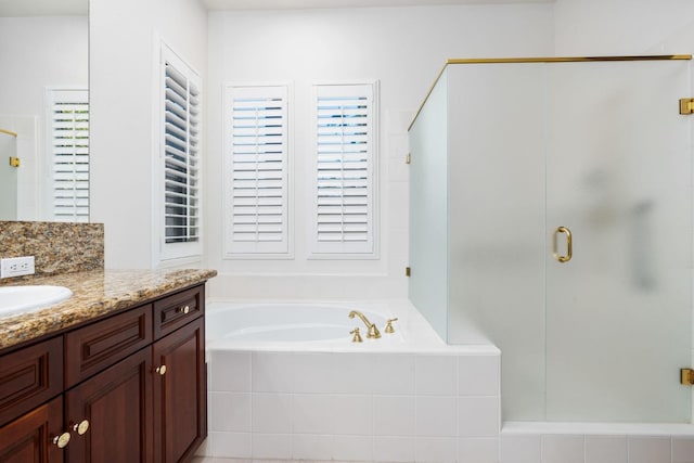 full bathroom featuring a stall shower, vanity, and a bath