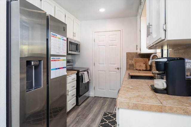 29598 Jim Bowie Ct, Coarsegold, CA 93614 - kitchen featuring white cabinets, appliances with stainless steel finishes, backsplash, dark wood-style flooring, and a sink