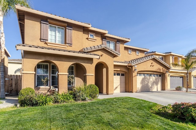 mediterranean / spanish-style house featuring fence, driveway, a tiled roof, stucco siding, and a front yard